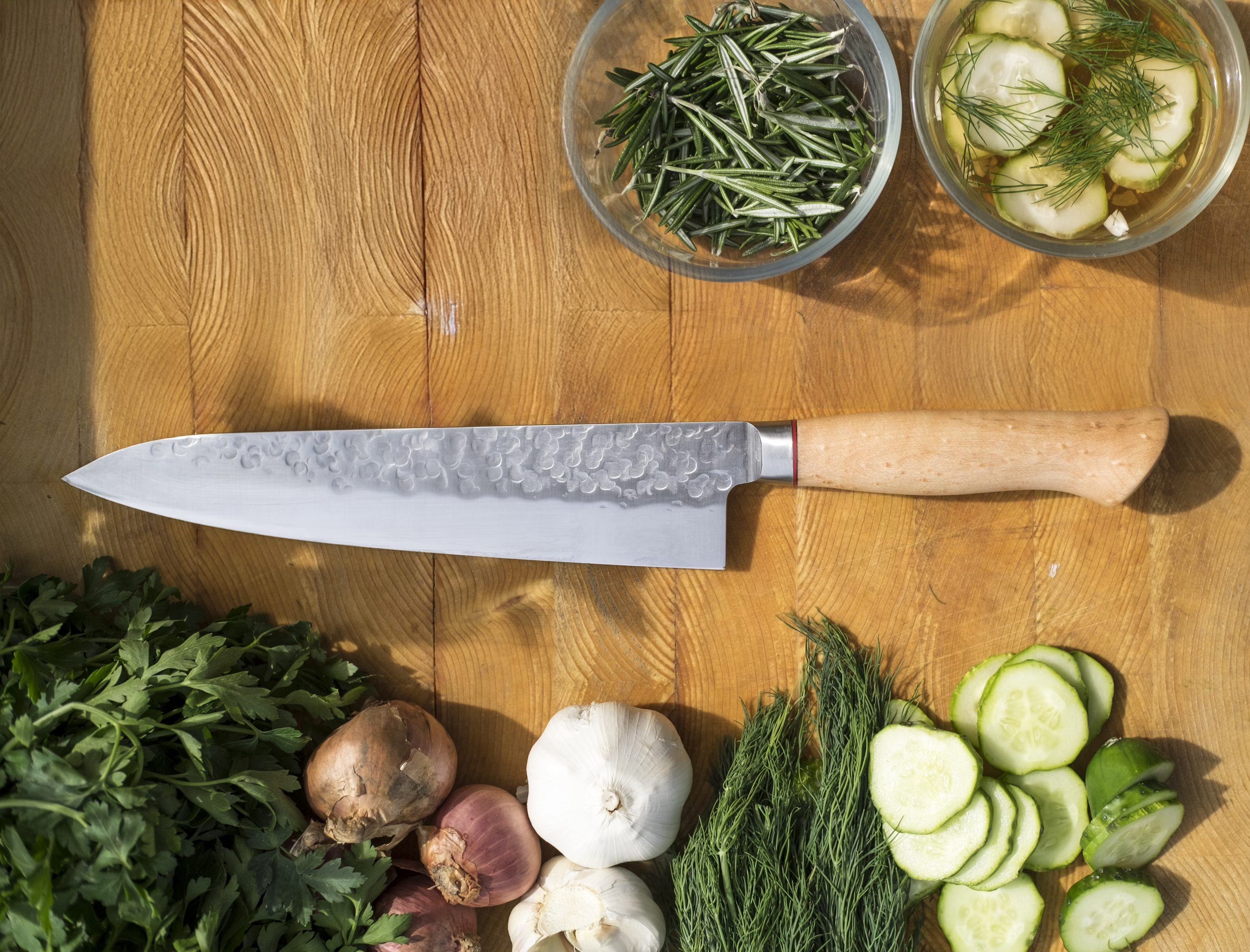 Professional knife on wooden cutting board with fresh ingredients